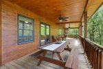 Main floor porch with a picnic table and rocking chairs